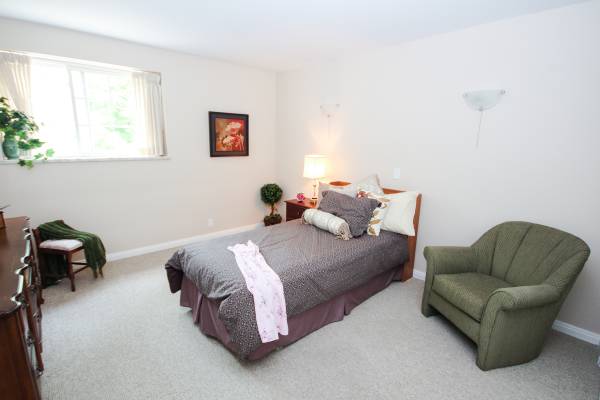A one-bedroom with a bed and an armchair.